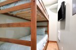 Bunk-room with a TV and pocket door for privacy